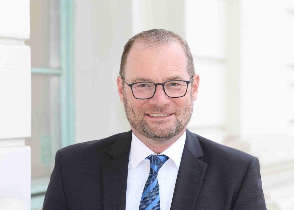 Mann im Anzug lächelt freundlich